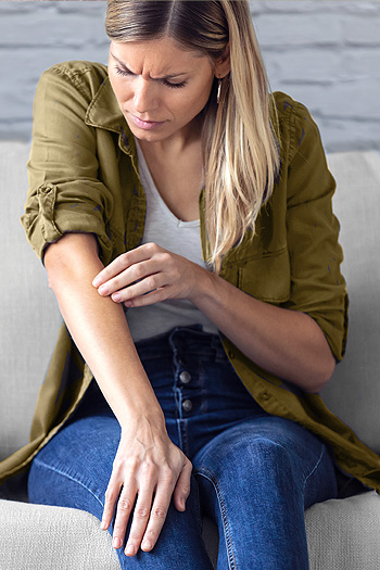 Close-up of middle-aged blonde woman seated on gray